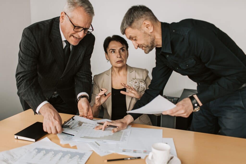 Drei Personen besprechen IT-Sicherheitslücken am Tisch (Foto: Vlada Karpovich / Pexels)